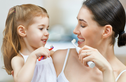 mother and daughter brushing teeth together